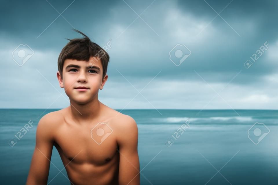 Teenage boy with wistful look against seascape