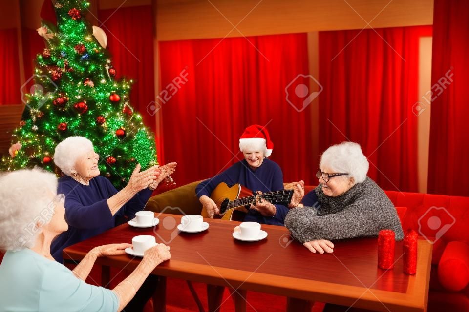 Elderly lady playing guitar at Christmas party