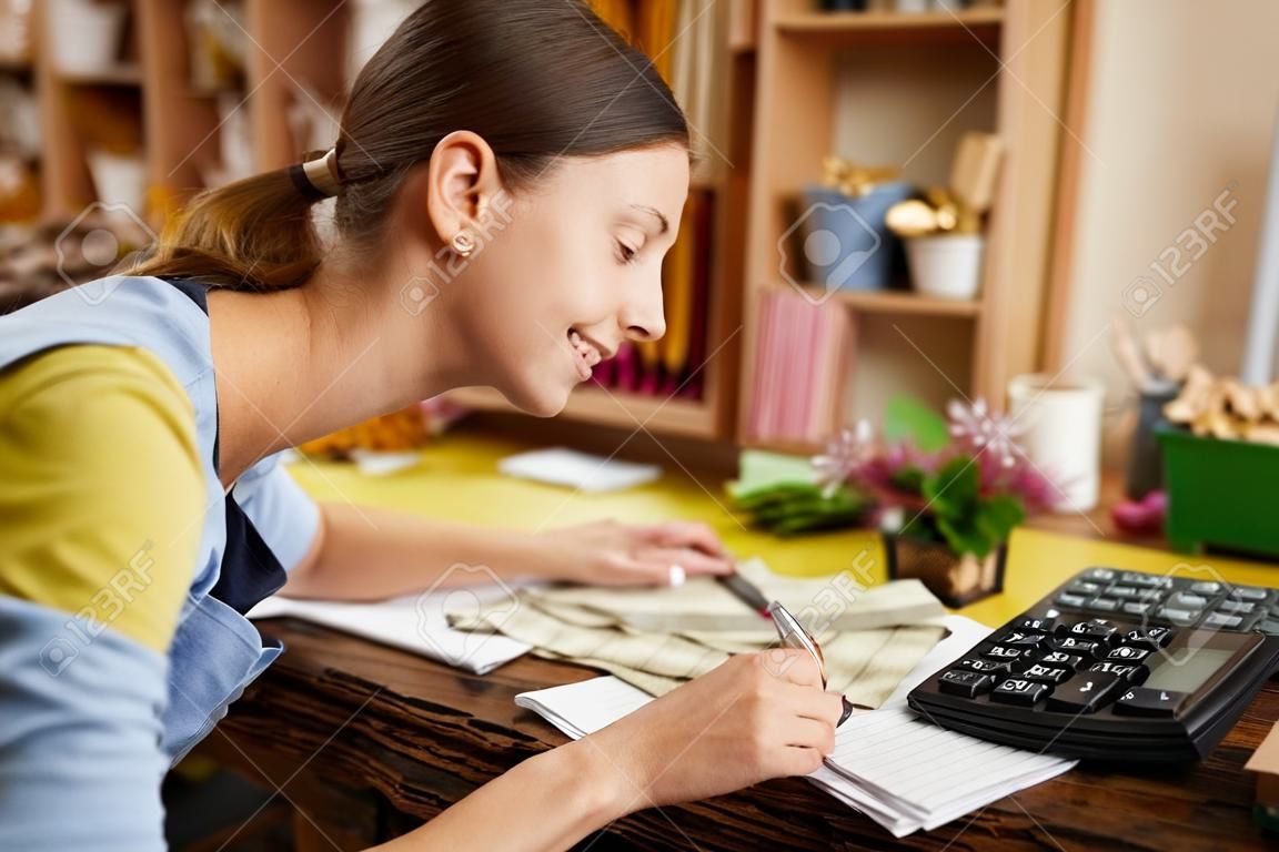 Femme faisant de la comptabilité en boutique