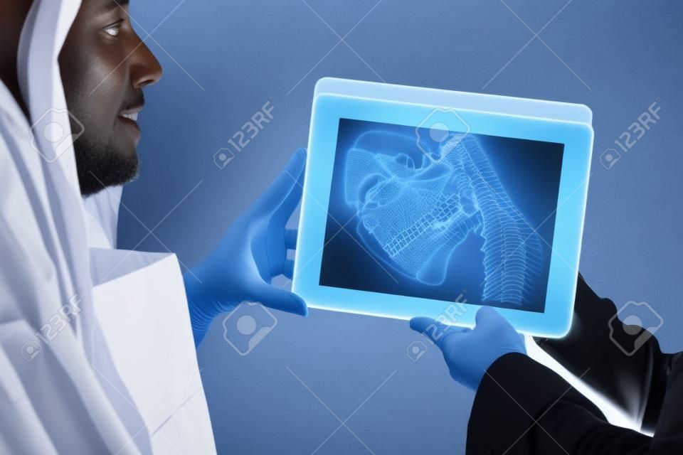 Lekarz pokazujący prześwietlenie szczęki pacjentowi