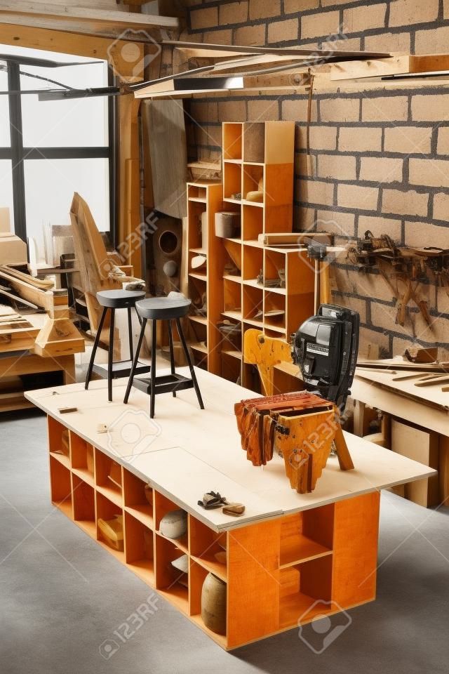 Vertical background image of artisan carpentry workshop in warm tones with focus on handcrafted designer furniture