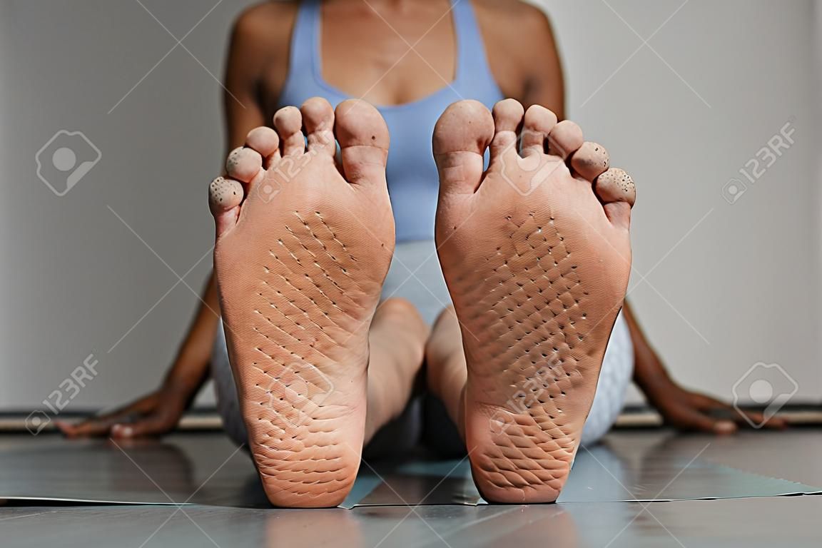 Vue de face gros plan des pieds féminins avec des marques de planche à ongles dans l'espace de copie du studio de yoga