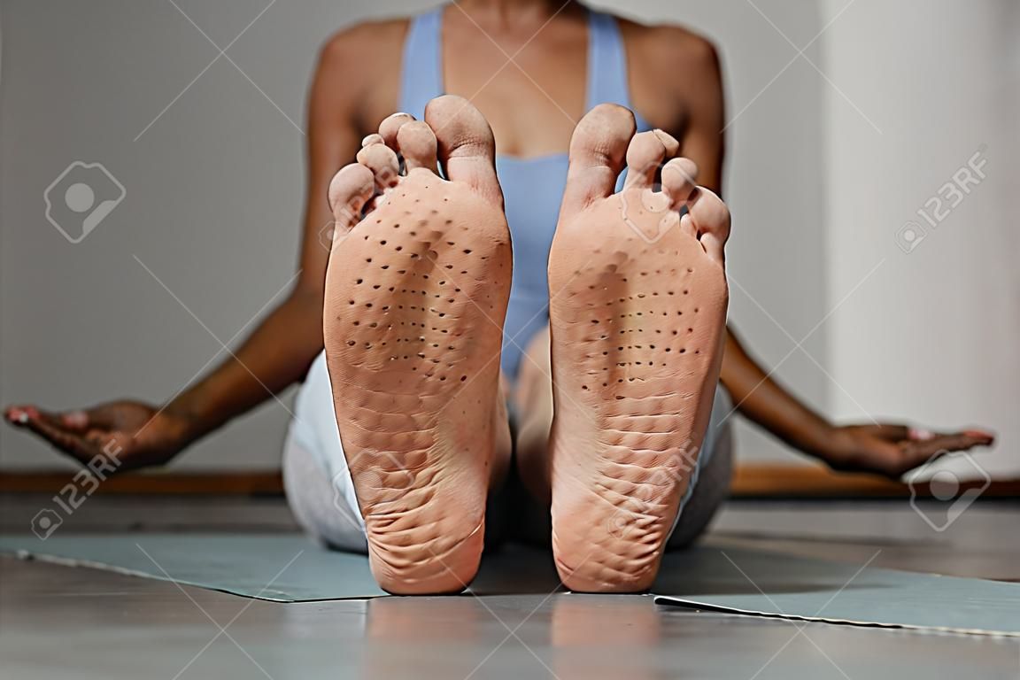 Primo piano vista frontale dei piedi femminili con segni sulla tavola del chiodo nello spazio della copia dello studio di yoga