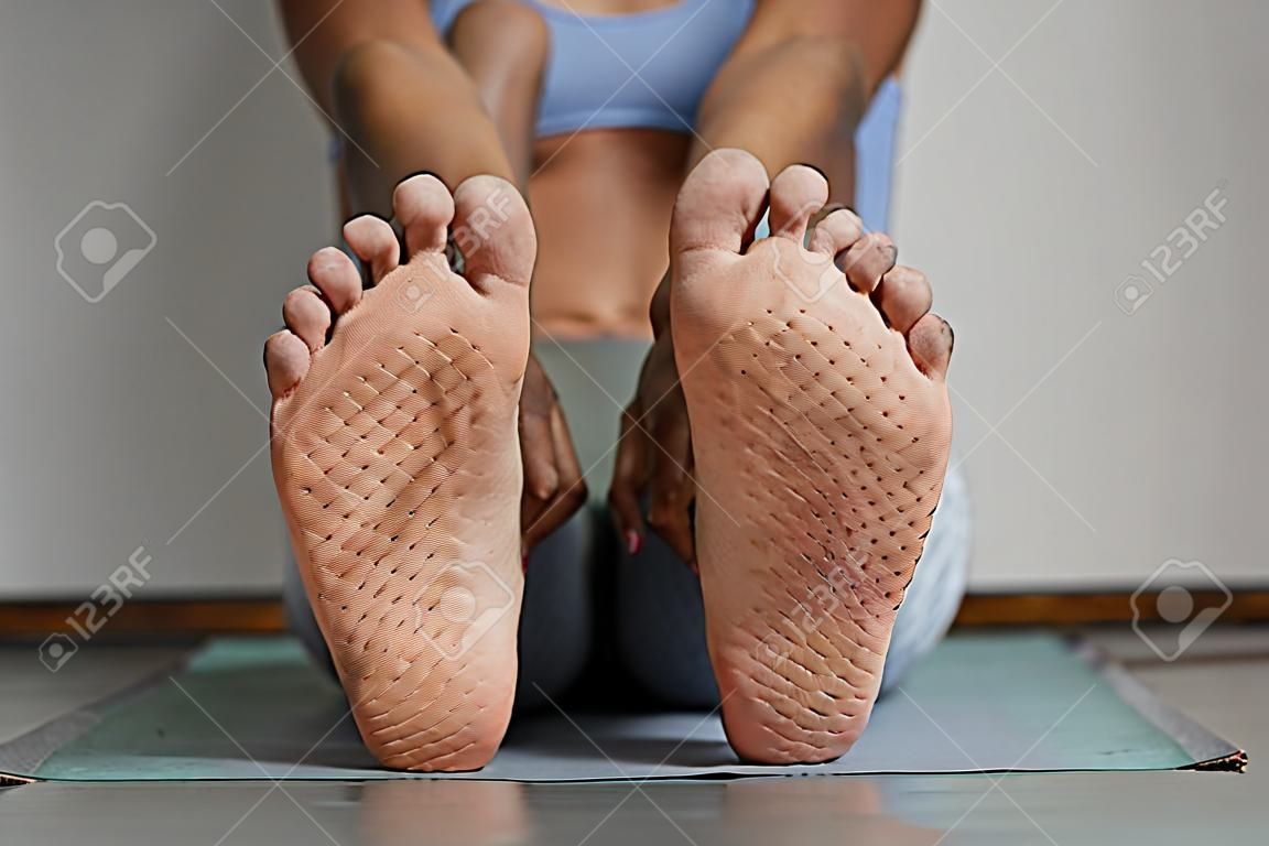 Primo piano vista frontale dei piedi femminili con segni sulla tavola del chiodo nello spazio della copia dello studio di yoga