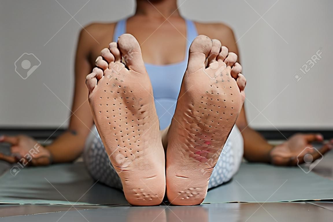 Front view closeup of female feet with nail board markings in yoga studio, copy space