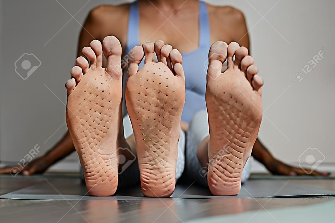 Vue de face gros plan des pieds féminins avec des marques de planche à ongles dans l'espace de copie du studio de yoga