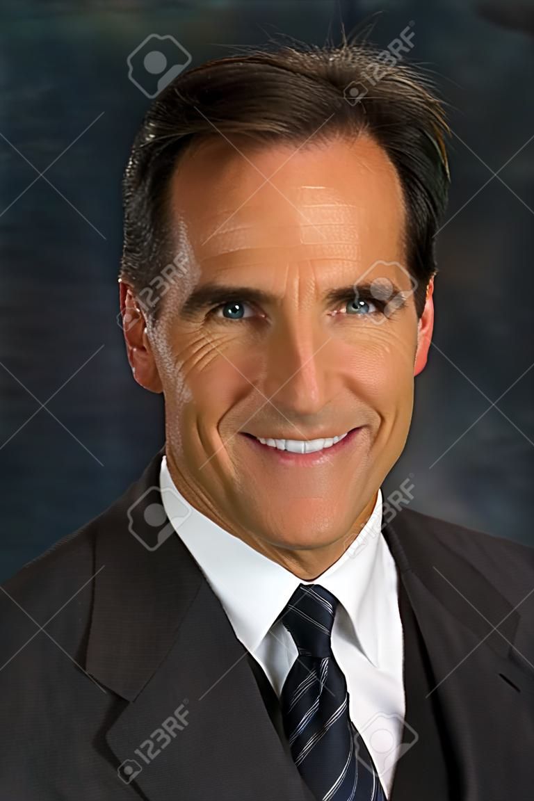 Headshot d'homme d'affaires d'âge moyen vêtu d'un veston et une cravate souriant.