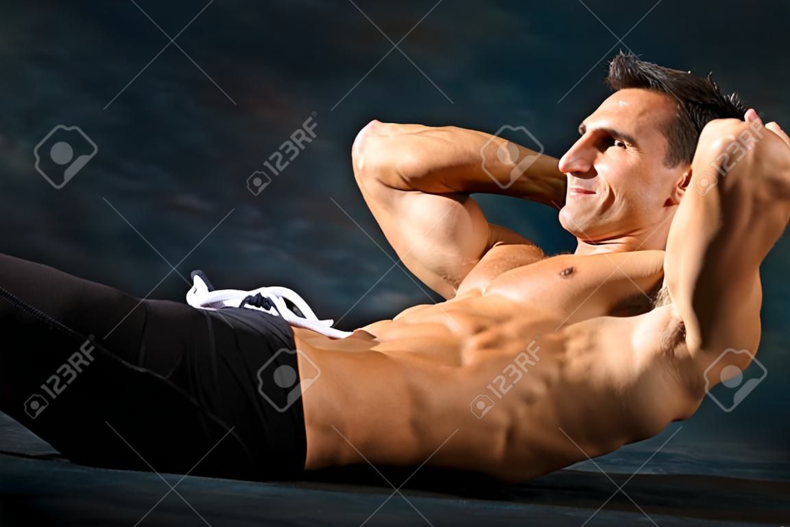 Athletic man performs situp calisthenics for abdominal strengthening.