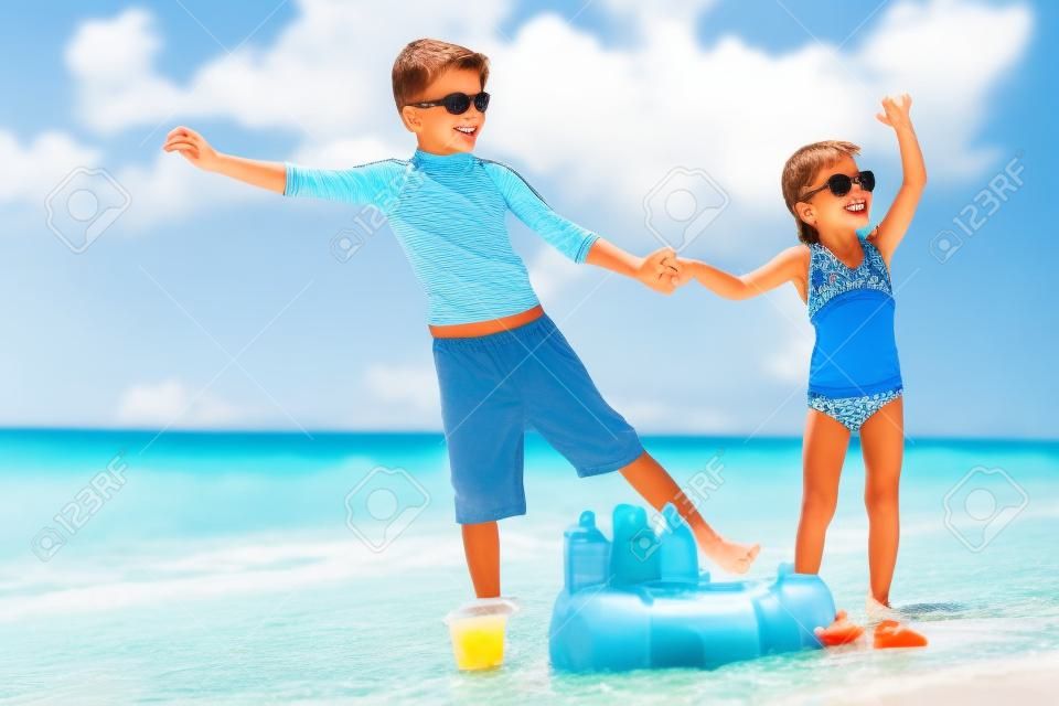 兄と妹の熱帯のビーチの休暇を楽しんで