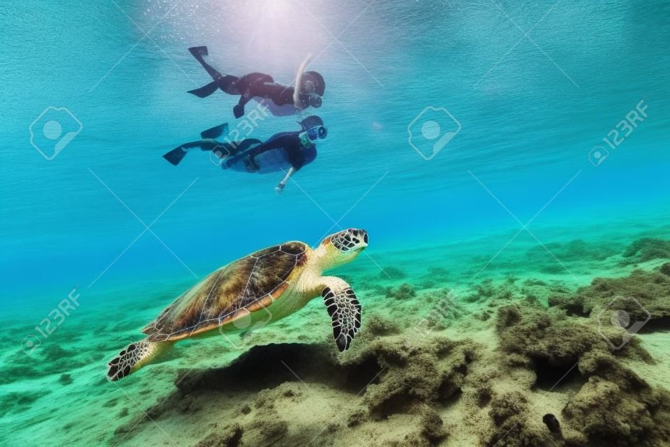 Foto subacuática de la madre de la familia y el snorkeling y la natación hijo con la tortuga carey