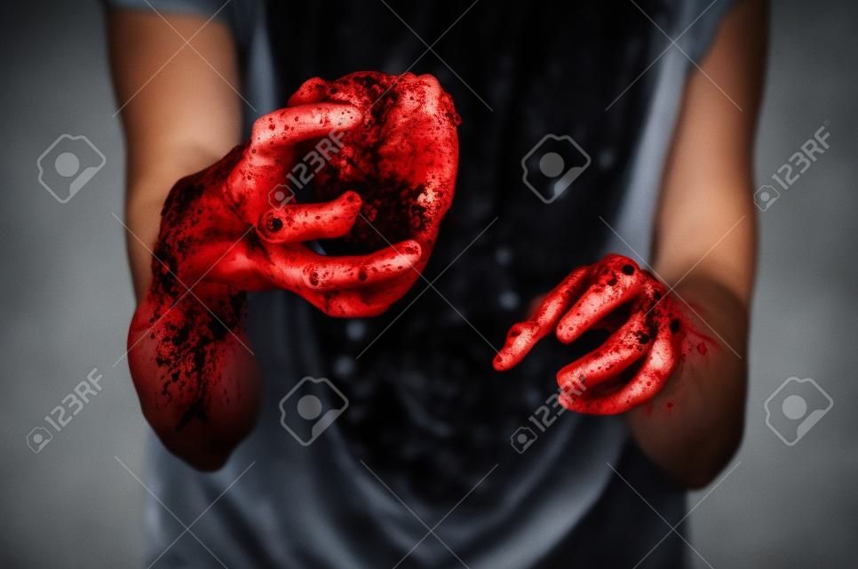 Bloody Halloween theme: crazy killer keeps bloody hands torn bloody human heart and experiencing depression and pain