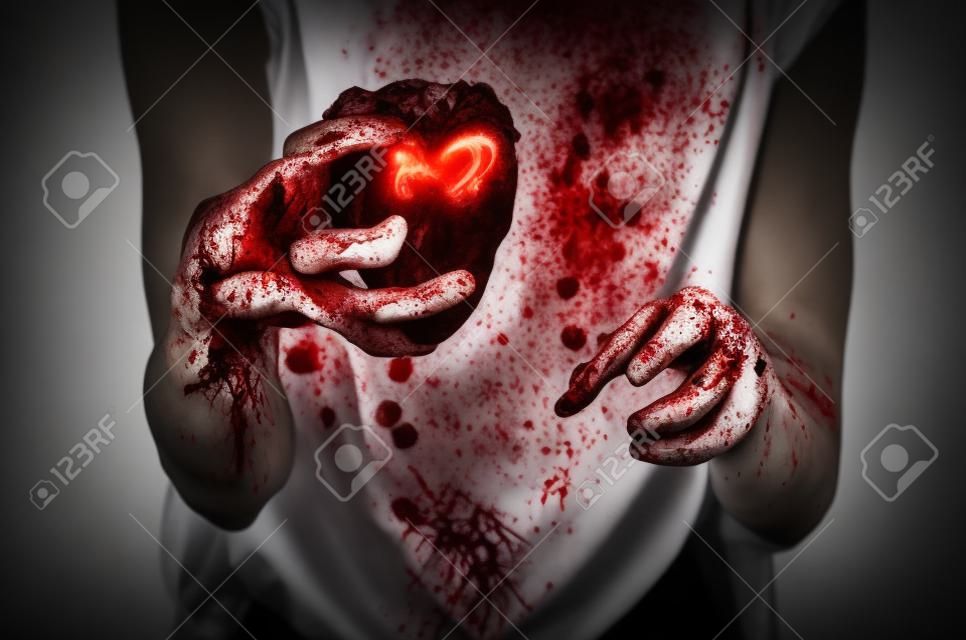 Bloody Halloween thema: gekke moordenaar houdt bloedige handen gescheurd bloederig menselijk hart en ervaren depressie en pijn