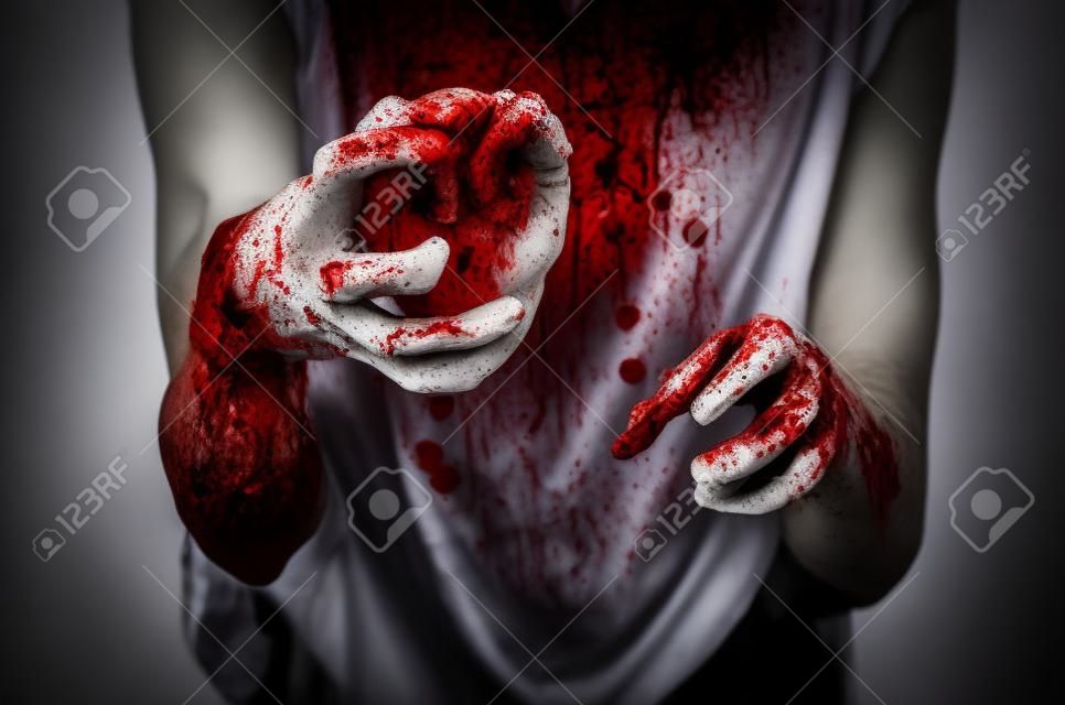 Bloody Halloween tema: asesino loco mantiene las manos sangrientas rasgados corazón humano con sangre y la depresión y el dolor que experimenta