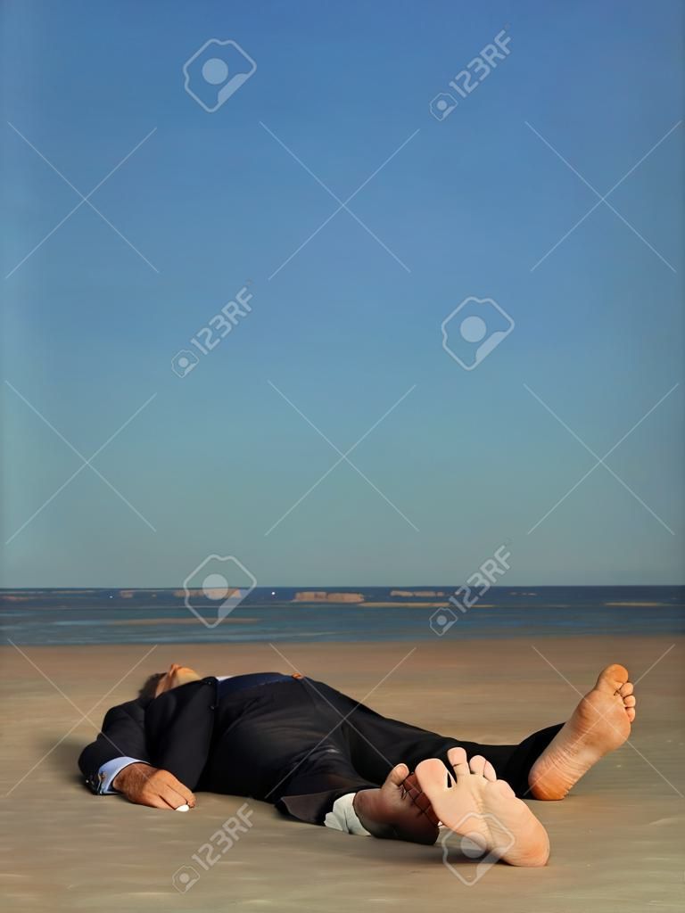 conceptual portrait of dead businessman, stranded on a desert beach, with a blank label attached to his toe