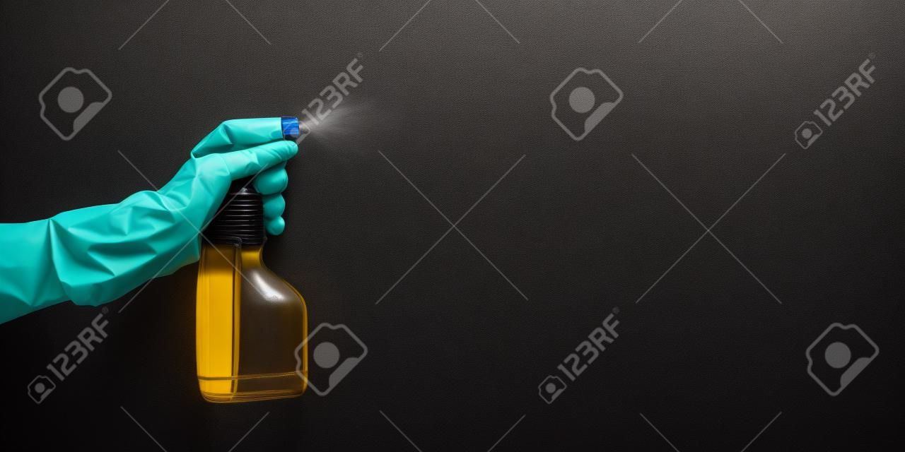 kéz gumikesztyű gazdaság tisztítás üveget és a permetezés folyékony, fekete háttér