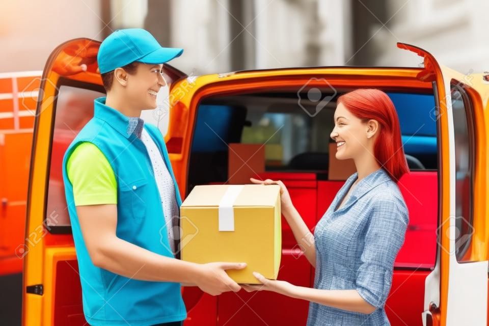 Colorful picture of courier delivers package for woman. They are looking at each other and smiling.