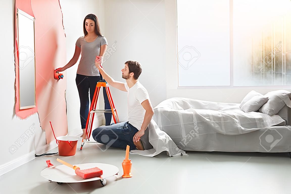 Młoda para robi naprawy mieszkania razem siebie