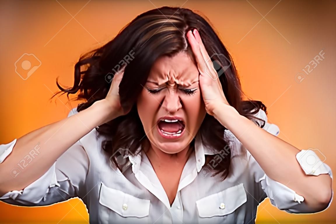 Closeup portrait stressed business woman having breakdown hysterical yelling screaming with temper tantrum isolated orange background. Negative human emotions facial expressions reaction attitude