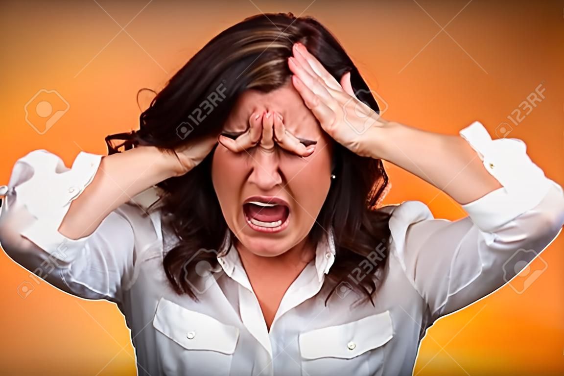 Closeup portrait stressed business woman having breakdown hysterical yelling screaming with temper tantrum isolated orange background. Negative human emotions facial expressions reaction attitude