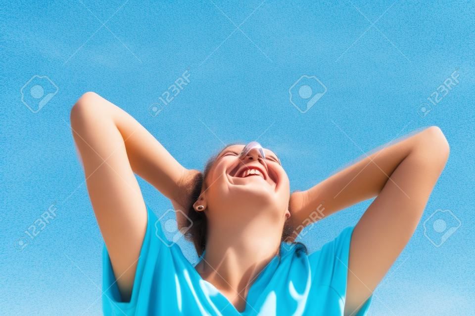 Sonriente mujer de los brazos levantados al cielo azul, celebración de la libertad. Emociones humanas positivas, expresión de la cara sintiéndose éxito percepción vida, la paz de la mente el concepto. Niña feliz gratuito en la playa disfrutando de la naturaleza