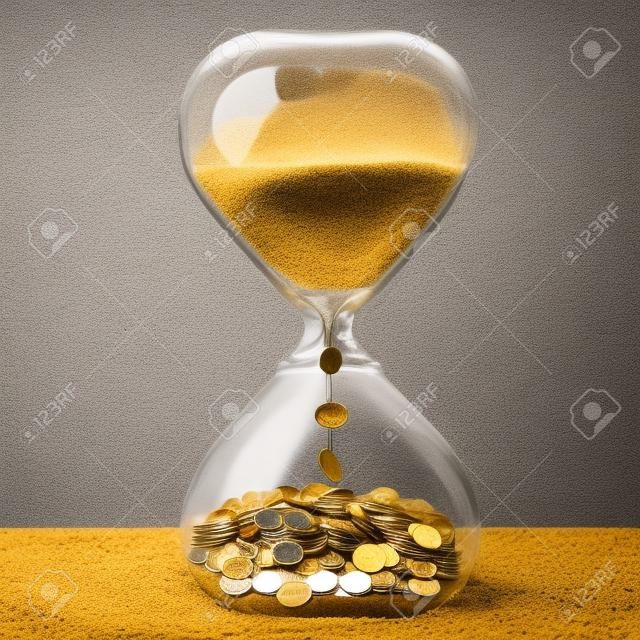 시간은 돈 금융 기회의 개념이다. 골드 먼지와 동전 모래 시계 회색 벽 배경에 고립