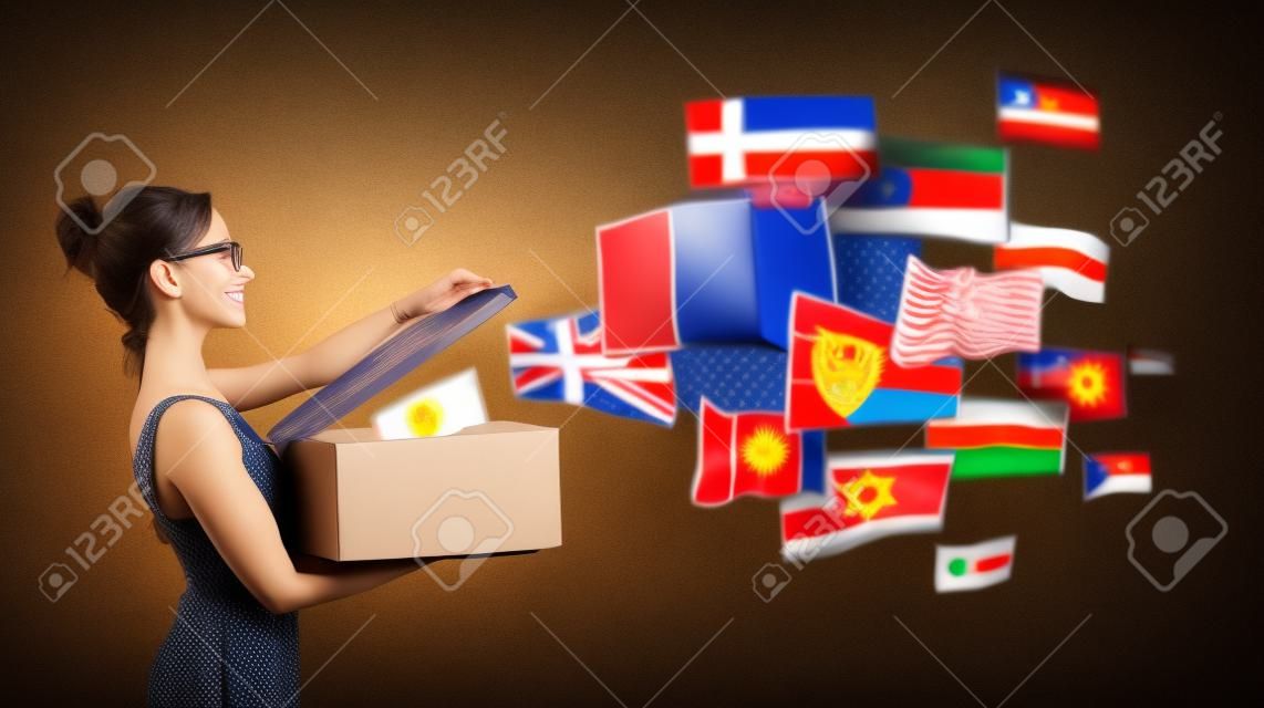 Jonge vrouw spreekt verschillende talen het openen van een doos met internationale vlaggen wegvliegen