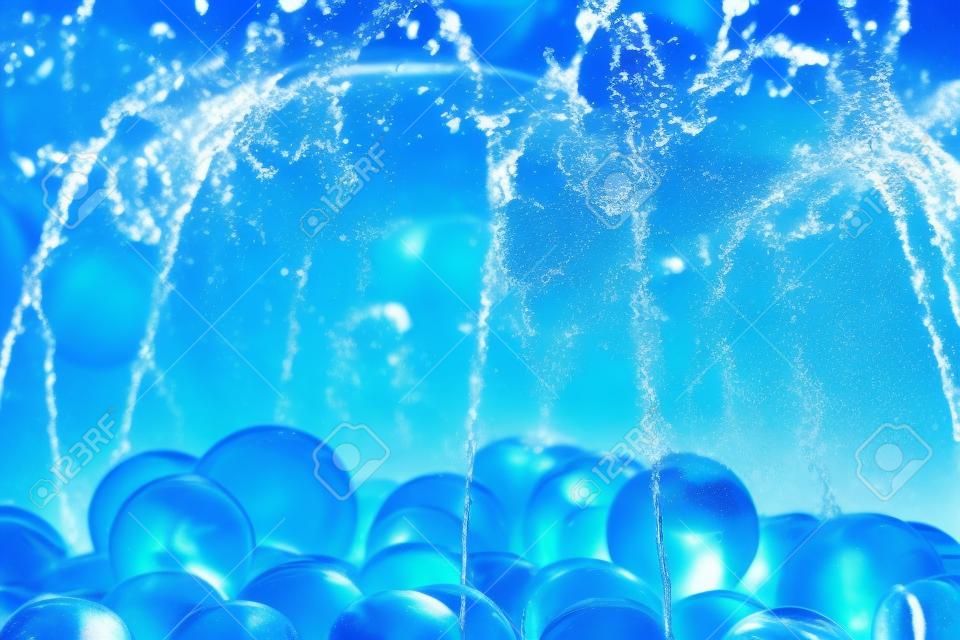 Water splash d'une fontaine avec boule de verre bleu.