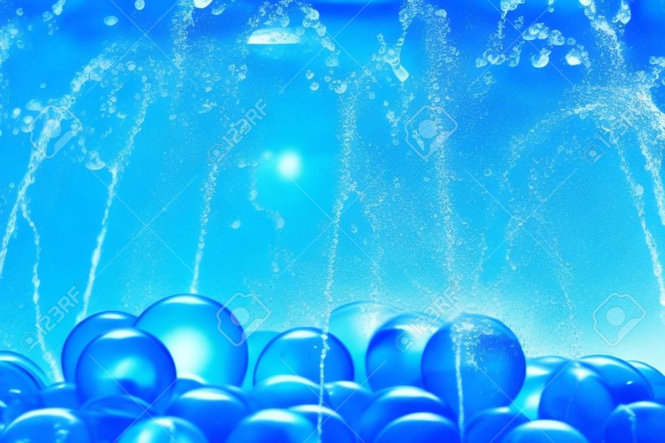 Water splash d'une fontaine avec boule de verre bleu.