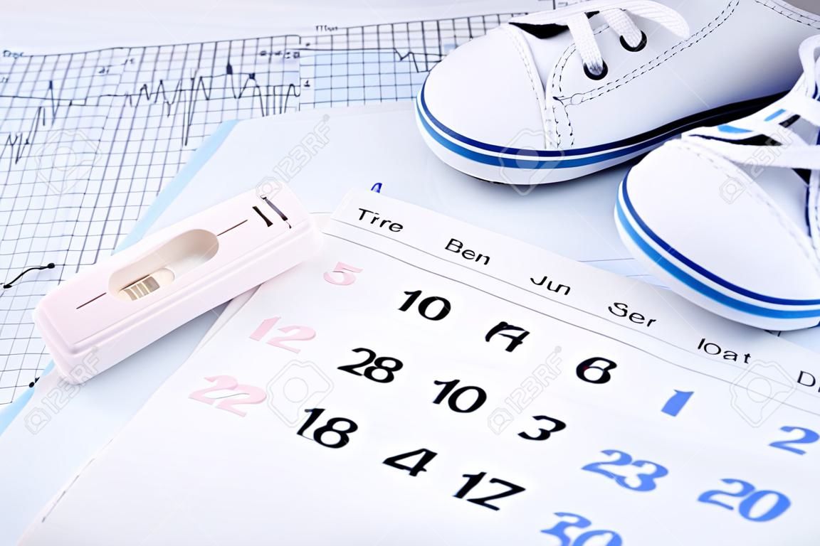 Pozytywny wynik testu ciążowego na kalendarzowych i buty dla dzieci