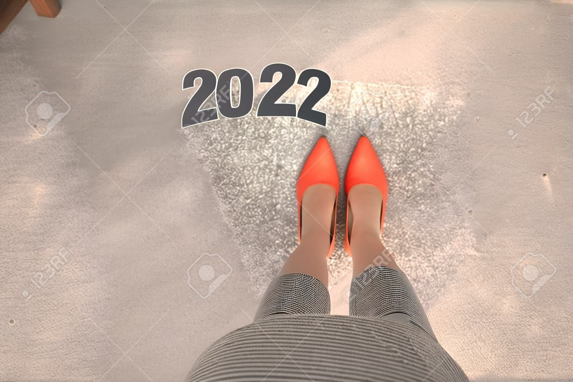 Top view of woman standing with orange shoes. New Year 2022 concept for business and career.