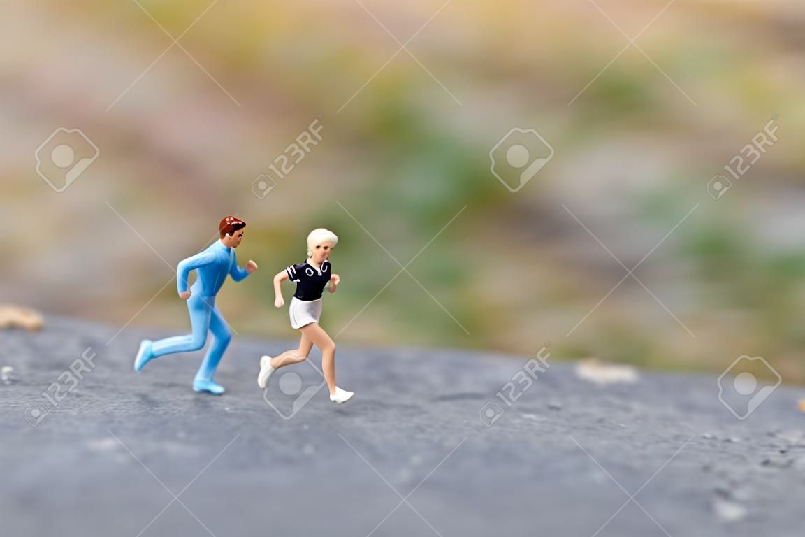 Gente en miniatura corriendo en The Rock, conceptos de salud y estilo de vida.