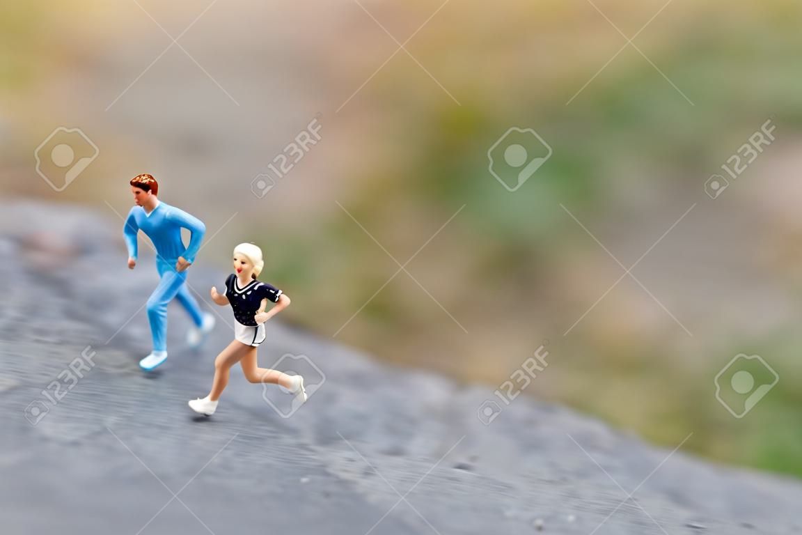 Gente en miniatura corriendo en The Rock, conceptos de salud y estilo de vida.