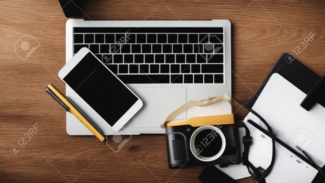 Top View Computer Laptop With Camera and Stationary on Wooden Table, Working Concept.