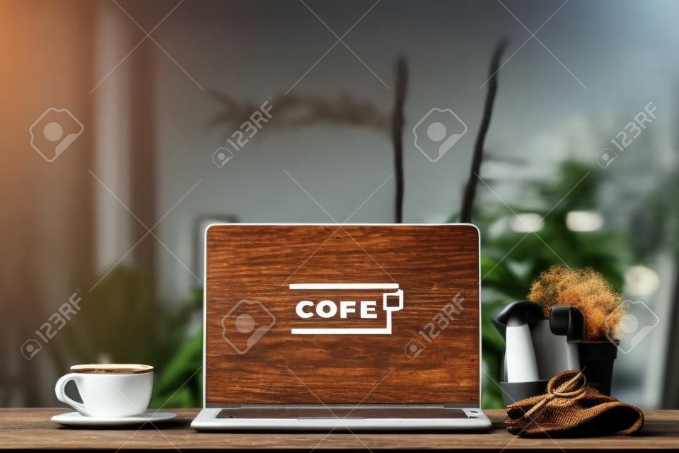 Laptop on wooden table, with cup of coffee and key