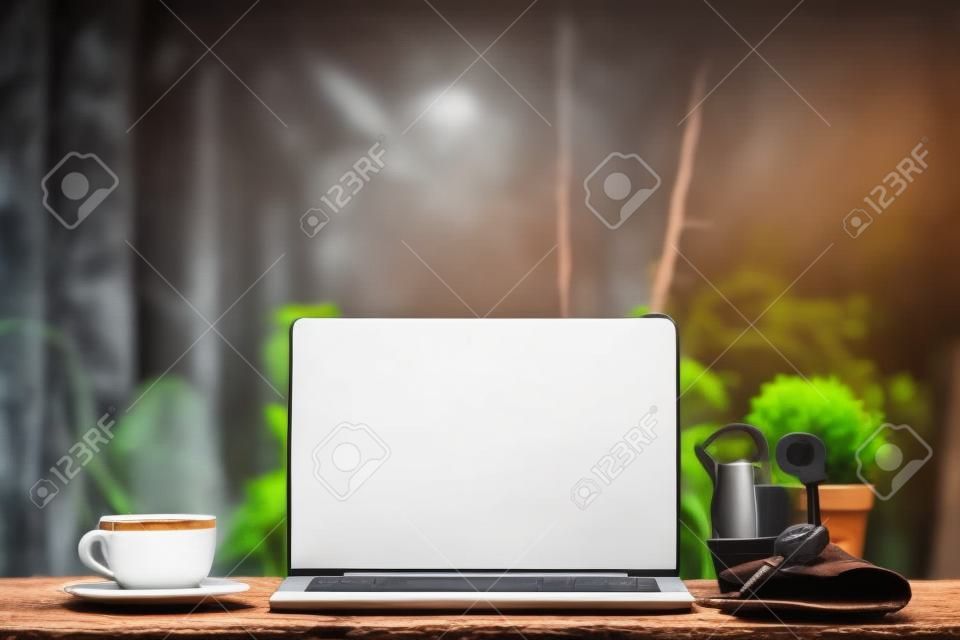 Laptop na drewnianym stole, z filiżanką kawy i kluczem
