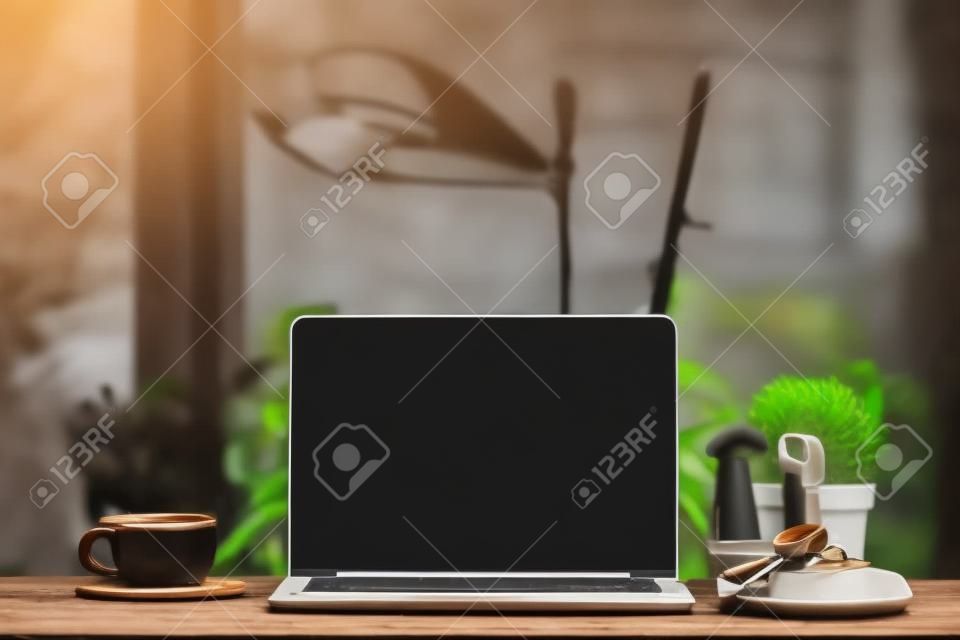 Laptop op houten tafel, met kopje koffie en sleutel