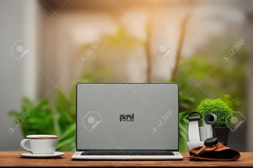 Laptop na drewnianym stole, z filiżanką kawy i kluczem