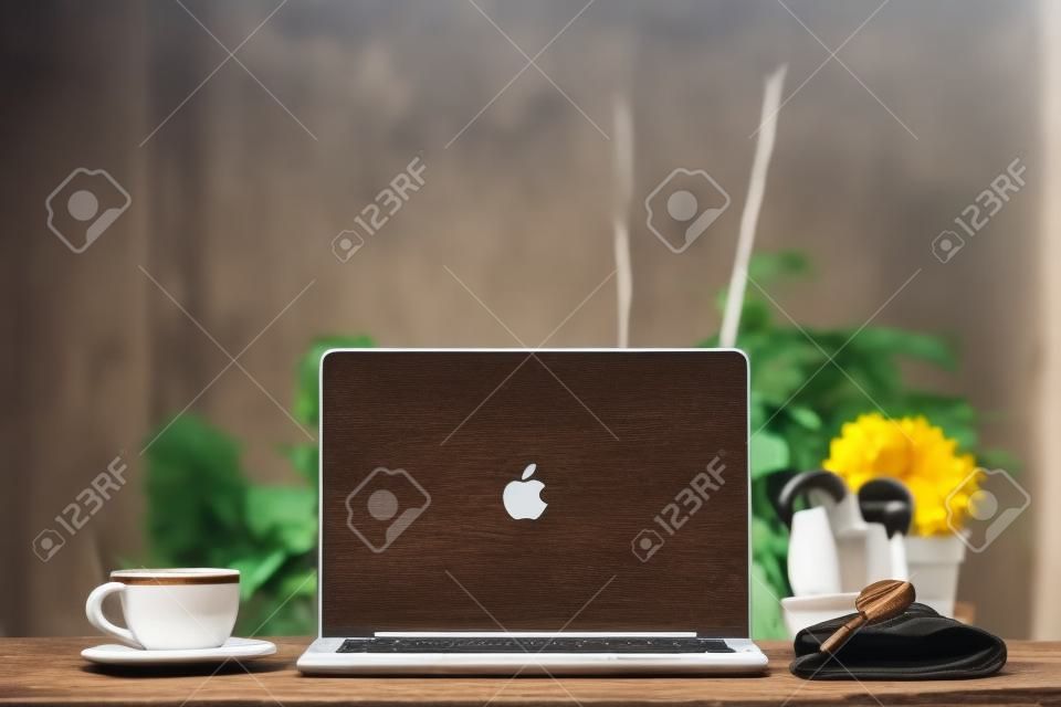 Laptop op houten tafel, met kopje koffie en sleutel