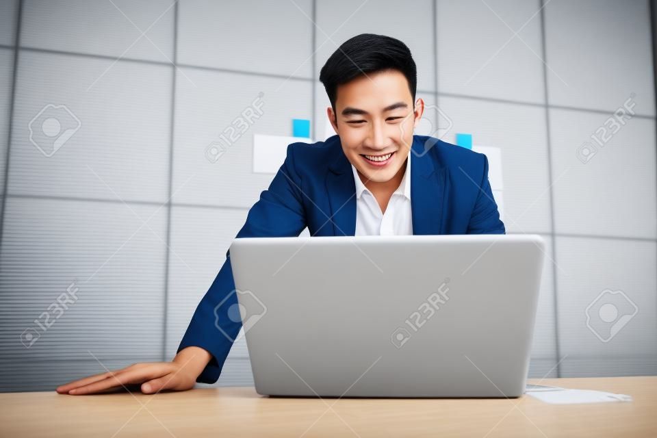 Happy Young Asian Businessman Working on Computer Laptop in Office