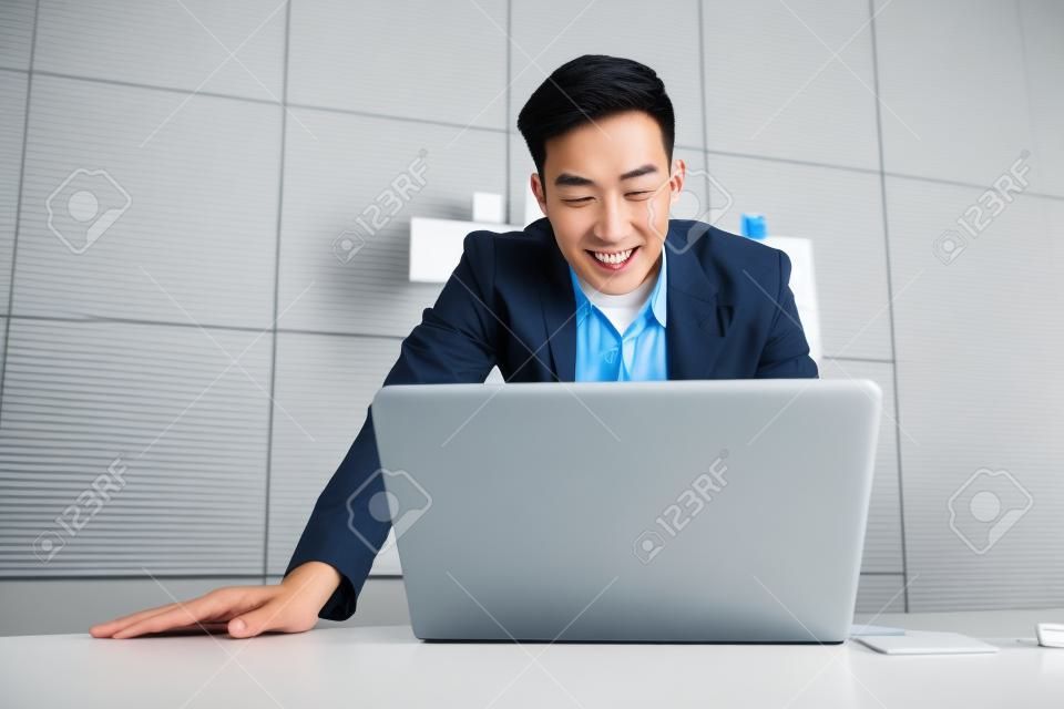 Happy Young Asian Businessman Working on Computer Laptop in Office