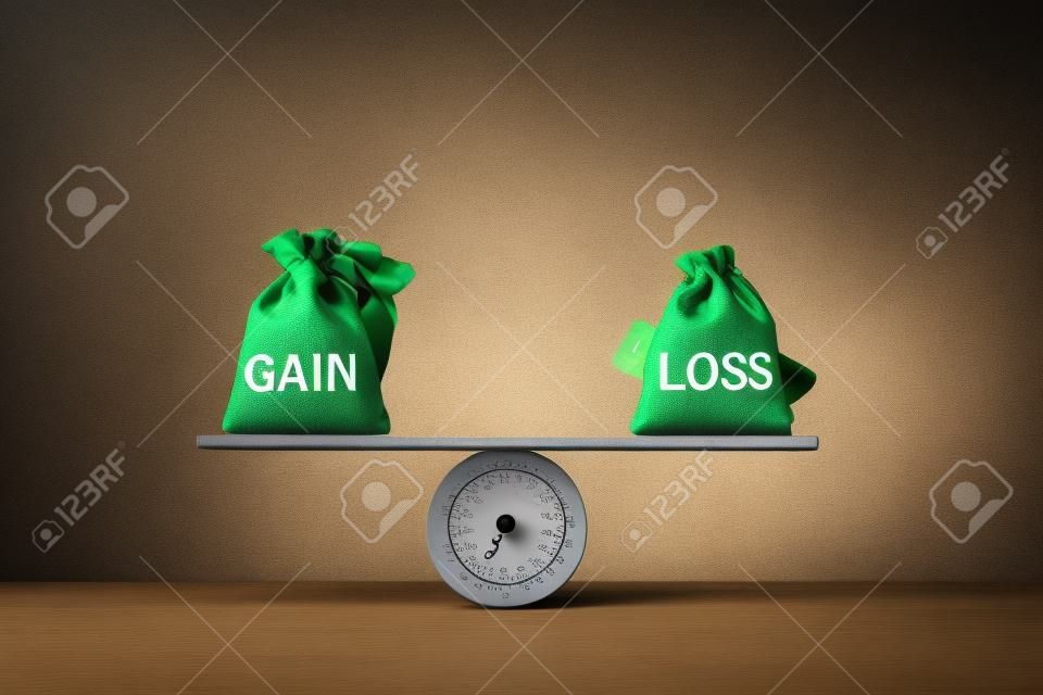 Gain and loss bags on a basic balance scale on blackboard. Capital investment gain and loss, financial concept, depicts balancing between profit and loss while managing assets e.g bonds, stocks, derivatives, ETFs