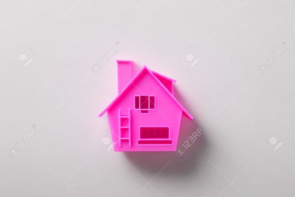 Modello di casa in plastica su rosa