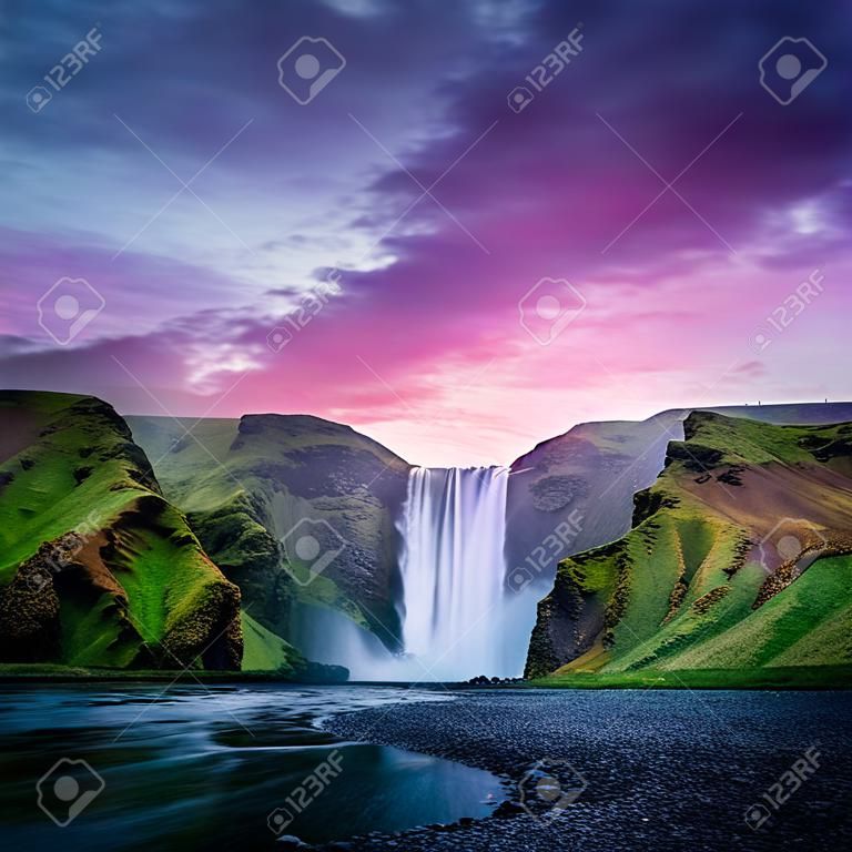 Słynny wodospad skogafoss na rzece skoga w czasie zachodu słońca. Islandia, Europa. wielkie fioletowe niebo świecące na tle. fotografia krajobrazowa