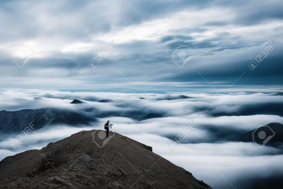 Fotógrafo paisajista tomando fotos de montañas nubladas y nubladas. Concepto de viaje, fotografía de paisaje.