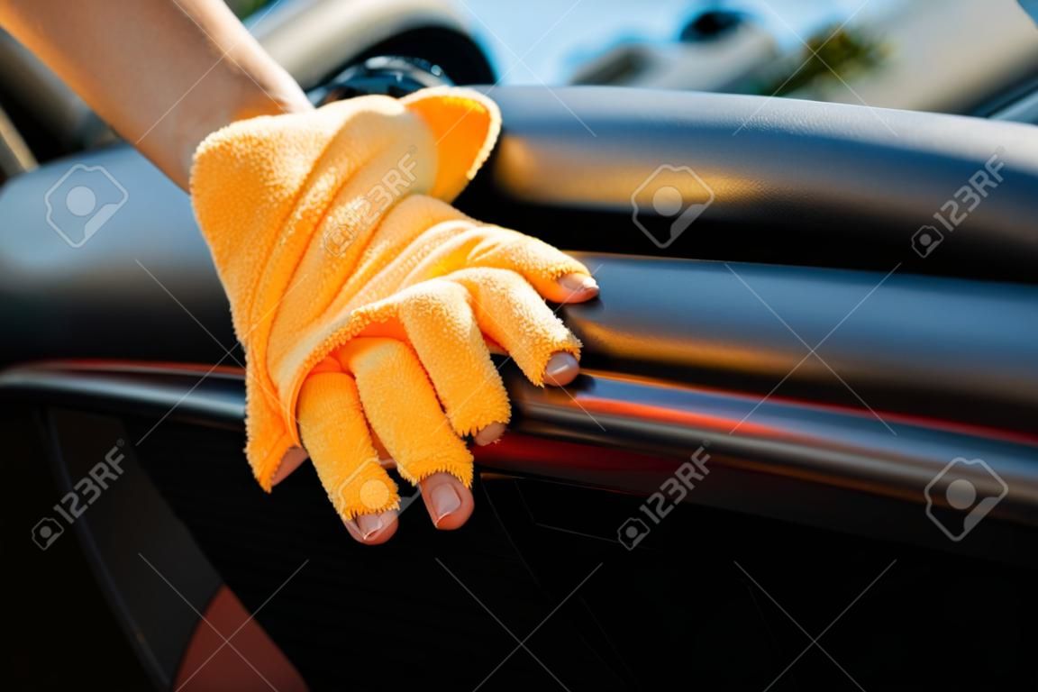 Picture of human hand with orange cloth washing machine interior
