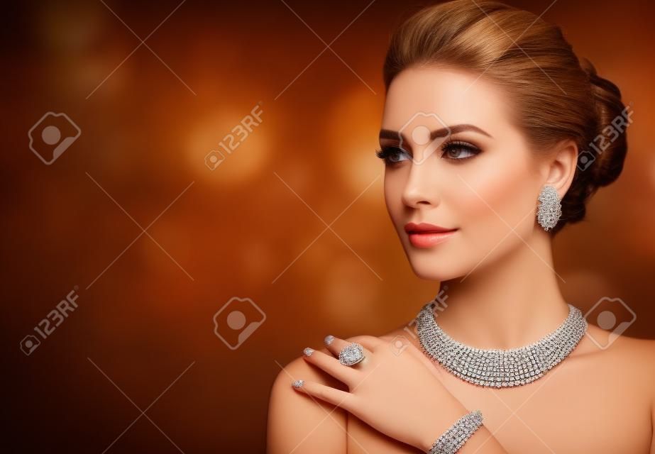 목걸이, 반지, 귀걸이로 구성된 호화로운 보석 세트를 입은 매혹적인 여성. 우아한 저녁 스타일.