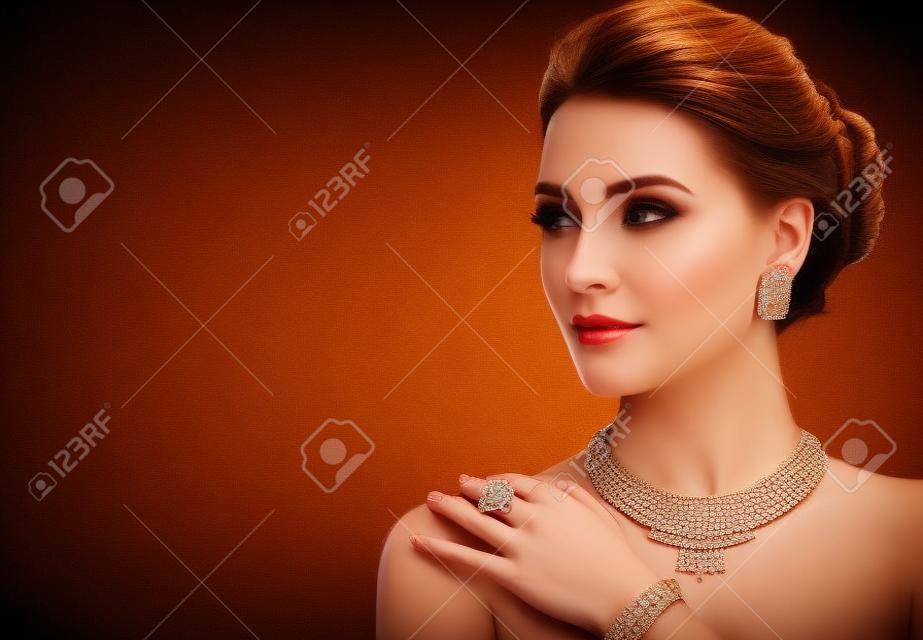 Seducente donna vestita con un elegante set di gioielli composto da collana, anello e orecchini. Stile da sera elegante.