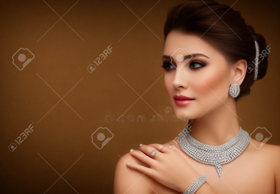 Verleidelijke vrouw gekleed in een chique sieraden set van ketting, ring en oorbellen. Elegante avond stijl.