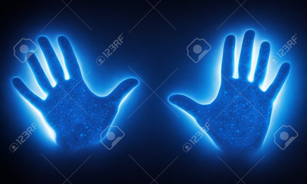 Ludzkie dłonie świecące od światła ultrafioletowego uv pokazujące bakterie i wirusy na czarnym tle, pokazujące znaczenie mycia rąk.
