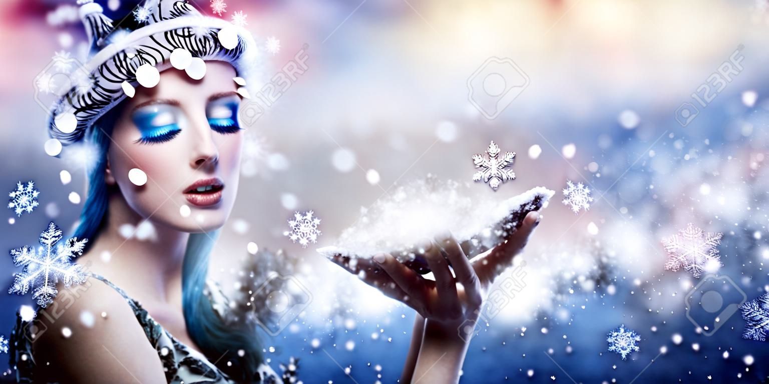 Desejo de inverno - Moda modelo soprando flocos de neve